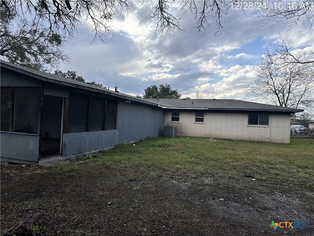 back of house featuring cooling unit, a yard, and a sunroom