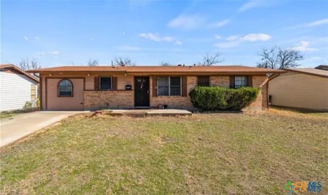 ranch-style home featuring brick siding and a front yard