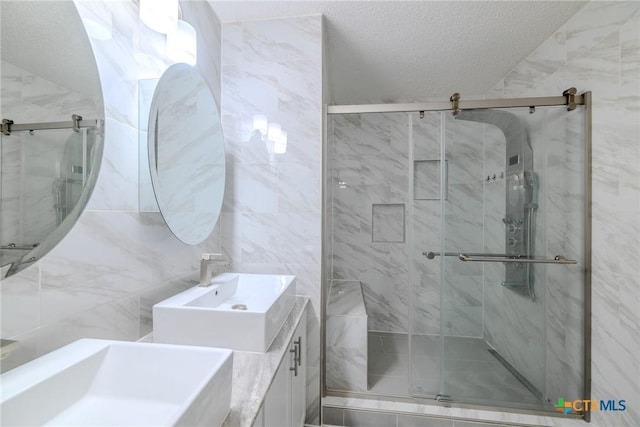 2703 Schulze Dr, Killeen, TX 76549 - bathroom with a sink, a stall shower, a textured ceiling, and tile walls