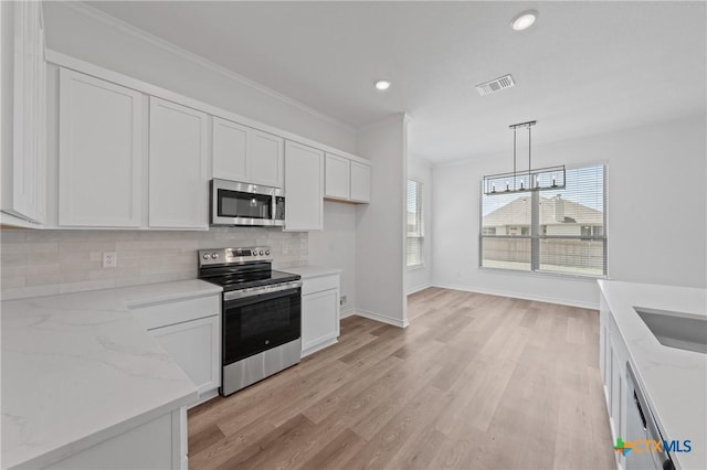 7915 Autumnwood Ln, Temple, TX 76502 - kitchen featuring appliances with stainless steel finishes, backsplash, baseboards, white cabinetry, and light stone countertops