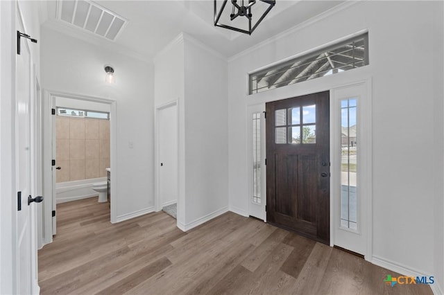 7915 Autumnwood Ln, Temple, TX 76502 - entryway with wood finished floors, crown molding, plenty of natural light, a chandelier, and baseboards