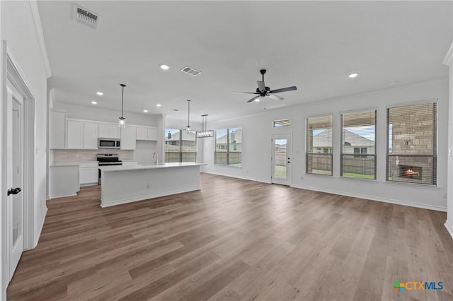 7915 Autumnwood Ln, Temple, TX 76502 - unfurnished living room with ceiling fan, recessed lighting, light wood-style flooring, baseboards, and crown molding
