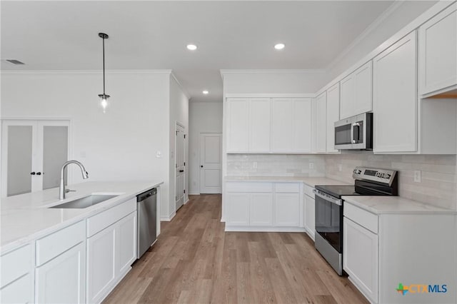 7915 Autumnwood Ln, Temple, TX 76502 - kitchen featuring stainless steel appliances, a sink, crown molding, decorative backsplash, and light wood finished floors