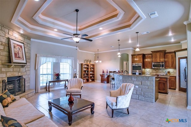 2601 Techny Dr, Harker Heights, TX 76548 - living area featuring a tray ceiling, a stone fireplace, light tile patterned floors, ceiling fan, and a chandelier