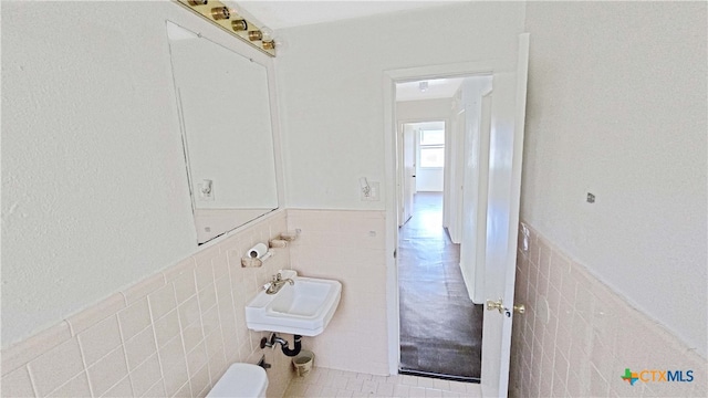 bathroom featuring tile walls, tile patterned flooring, and sink