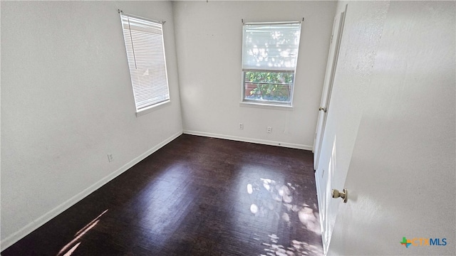 unfurnished room with dark hardwood / wood-style flooring