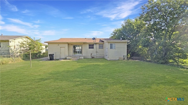 rear view of house with a yard