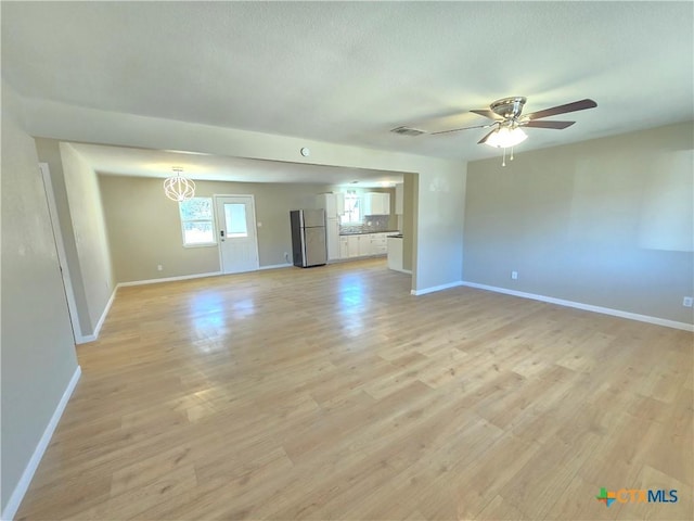 unfurnished living room with ceiling fan and light hardwood / wood-style flooring