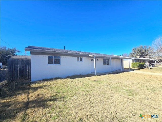 rear view of property featuring a lawn