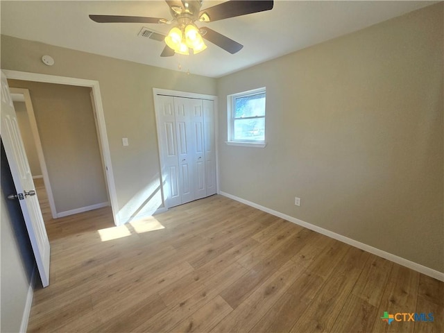 unfurnished bedroom with light hardwood / wood-style floors, a closet, and ceiling fan