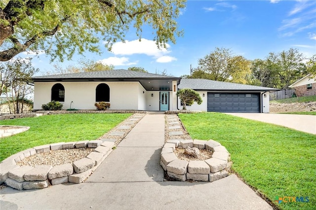 single story home featuring a garage, a fire pit, and a front yard