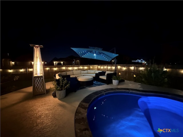 pool at twilight with a patio area