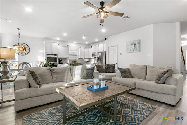 living room with hardwood / wood-style flooring and ceiling fan