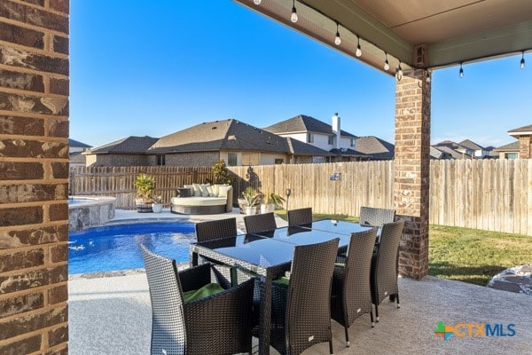 view of patio with pool water feature and a fenced in pool