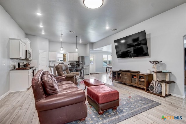 living room featuring visible vents and light wood finished floors