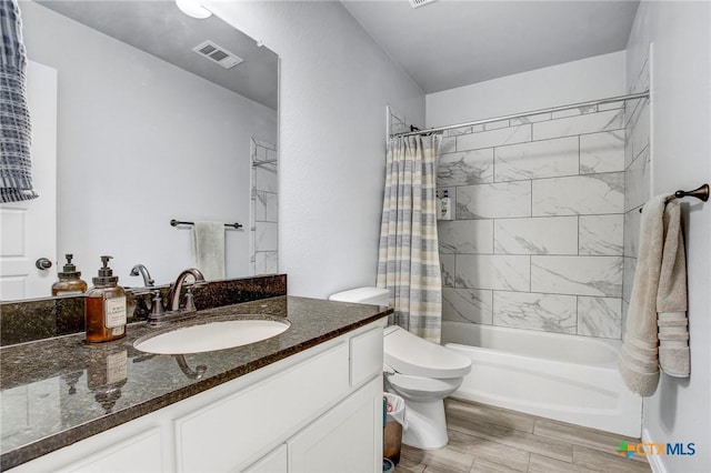bathroom featuring shower / bath combo, vanity, toilet, visible vents, and wood finished floors