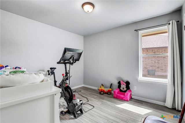 workout area featuring wood finished floors and baseboards
