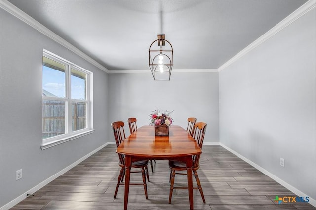 dining room featuring baseboards, dark wood-style floors, and crown molding