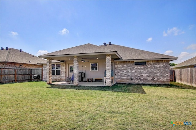 back of house featuring a lawn, ceiling fan, a patio area, and a fenced backyard