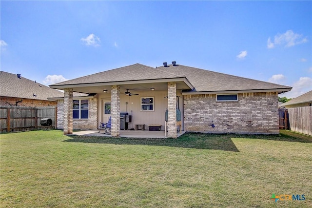 back of house featuring a patio area, a shingled roof, ceiling fan, a yard, and a fenced backyard