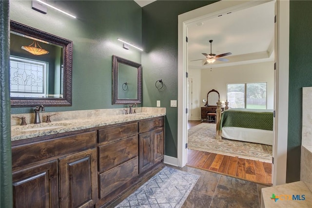 217 Foxwood, New Braunfels, TX 78132 - ensuite bathroom featuring a ceiling fan, a sink, a raised ceiling, and ensuite bath