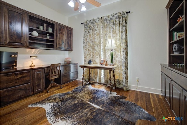 217 Foxwood, New Braunfels, TX 78132 - home office featuring dark wood-style flooring, a ceiling fan, baseboards, and built in desk