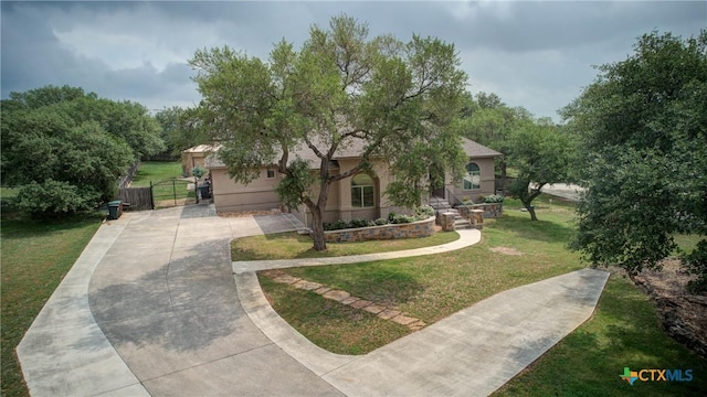 217 Foxwood, New Braunfels, TX 78132 - view of front facade featuring fence, stucco siding, a front yard, a gate, and driveway