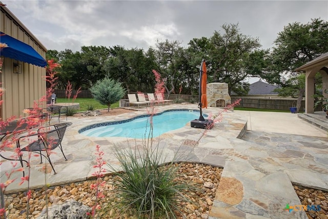 217 Foxwood, New Braunfels, TX 78132 - view of swimming pool featuring an outdoor stone fireplace, a fenced in pool, a fenced backyard, and a patio area