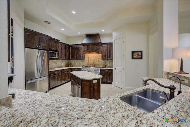 217 Foxwood, New Braunfels, TX 78132 - kitchen with light stone counters, a sink, stainless steel appliances, custom range hood, and visible vents