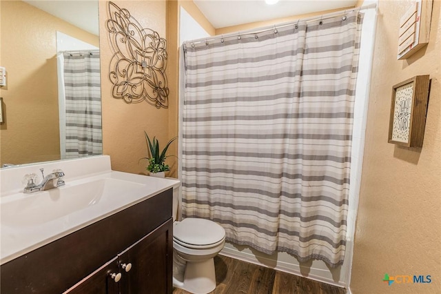 bathroom featuring hardwood / wood-style floors, vanity, and toilet