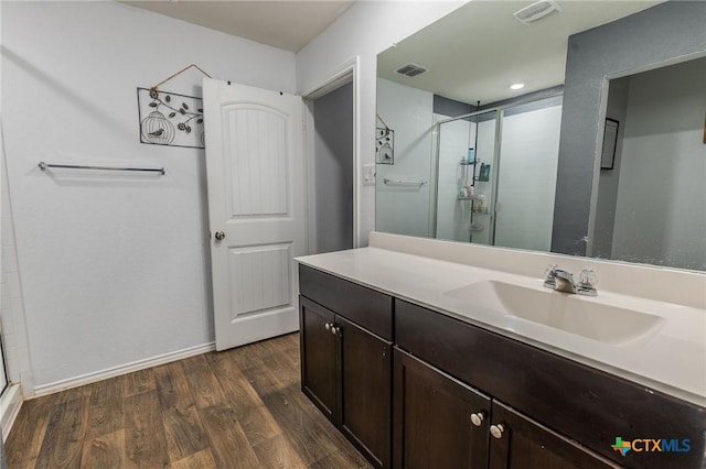 bathroom featuring hardwood / wood-style floors, vanity, and an enclosed shower