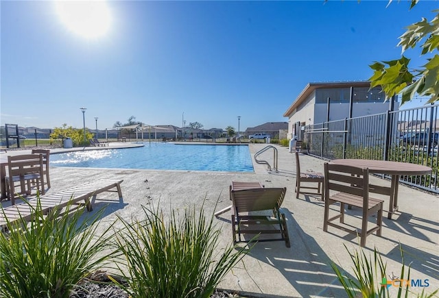 view of pool with pool water feature and a patio