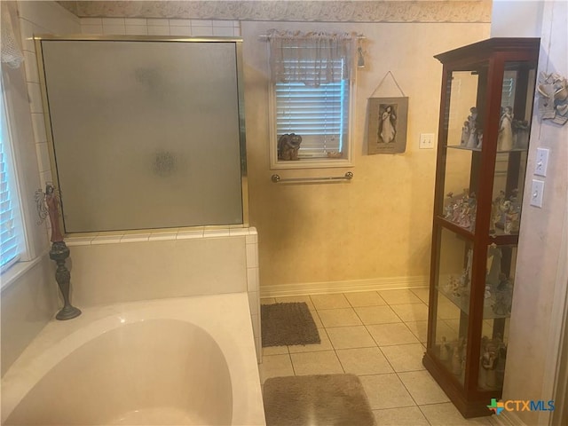 1002 Magnolia St, Belton, TX 76513 - full bathroom featuring a stall shower, tile patterned flooring, a bath, and baseboards