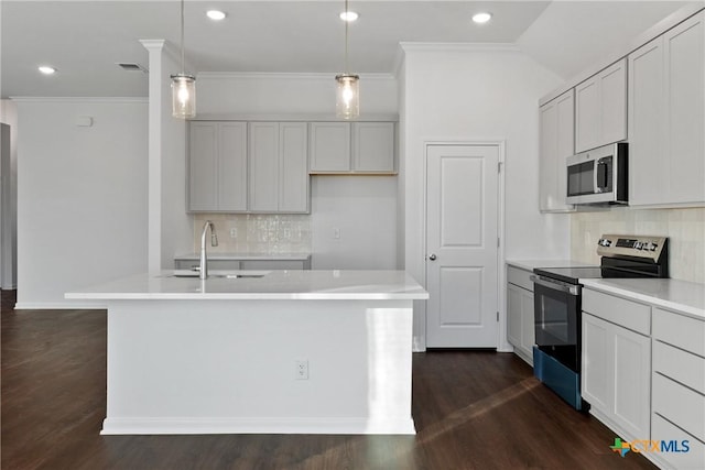 kitchen with pendant lighting, sink, a kitchen island with sink, stainless steel appliances, and dark hardwood / wood-style flooring