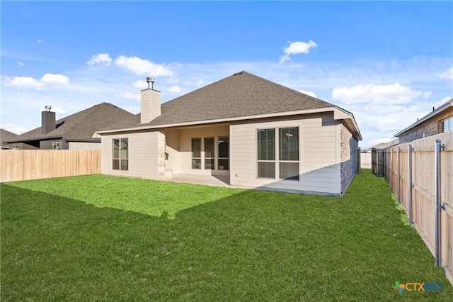 rear view of house with a yard and a patio area