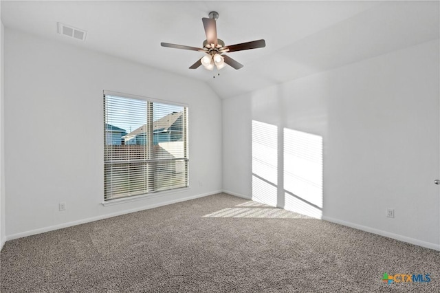 empty room featuring ceiling fan, lofted ceiling, and carpet flooring