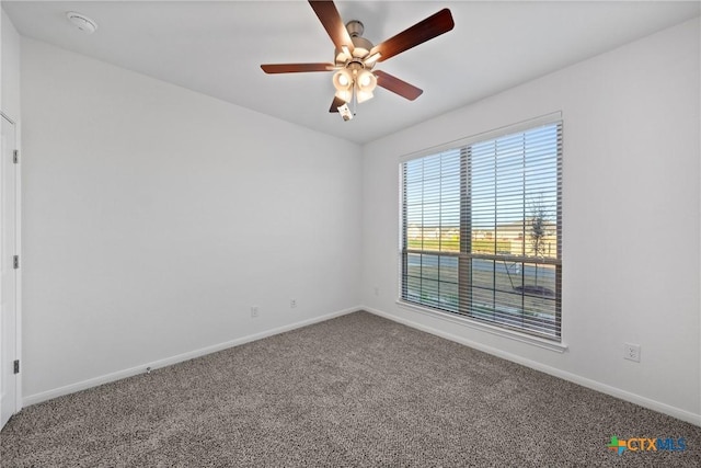 empty room featuring ceiling fan and carpet