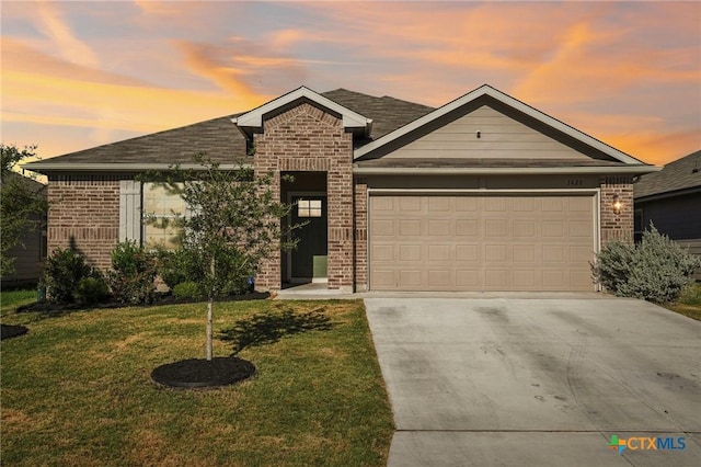 view of front of property with a garage and a lawn