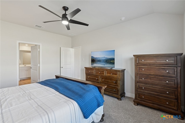 carpeted bedroom with ensuite bathroom, ceiling fan, and vaulted ceiling