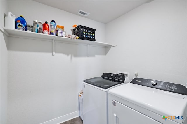 laundry area with washer and dryer and dark wood-type flooring