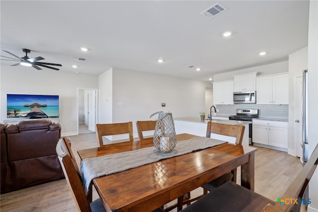 dining area featuring ceiling fan, sink, and light hardwood / wood-style floors