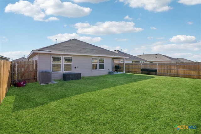 rear view of property with a lawn and central AC unit