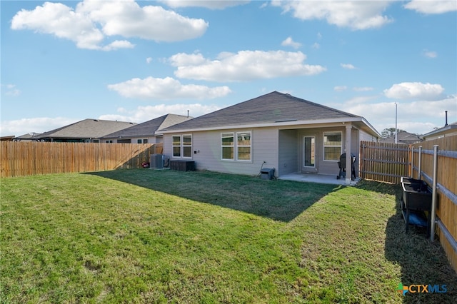 rear view of house featuring a yard, a patio, and central AC