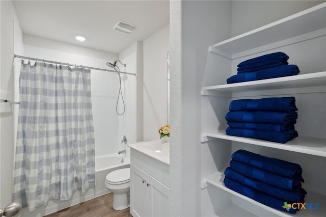 full bathroom featuring hardwood / wood-style floors, vanity, shower / bath combo, and toilet