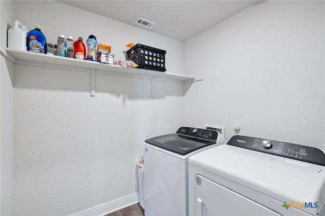 laundry area featuring washing machine and clothes dryer and dark hardwood / wood-style floors