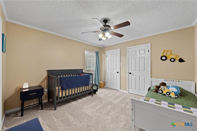 bedroom featuring baseboards, a ceiling fan, crown molding, a textured ceiling, and carpet flooring