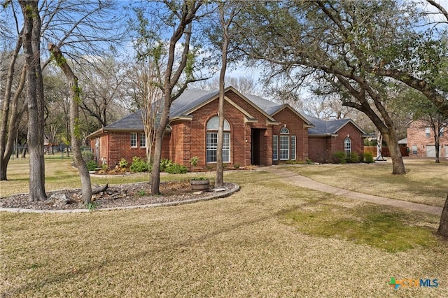 view of front facade featuring brick siding and a front lawn