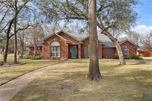 ranch-style home featuring brick siding and a front lawn