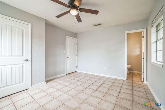 801 E Johnson St, Burnet, TX 78611 - unfurnished bedroom featuring light tile patterned floors, ceiling fan, and baseboards