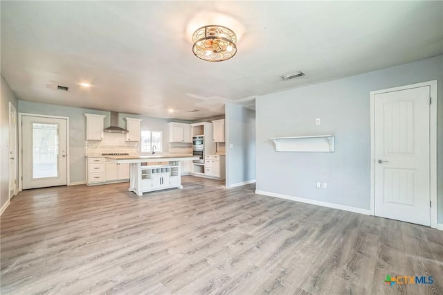 801 E Johnson St, Burnet, TX 78611 - unfurnished living room featuring light wood-style flooring, a sink, and baseboards